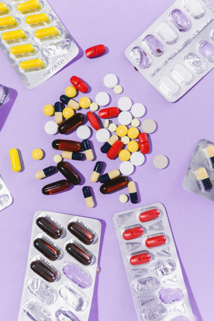 pexels-photo-9742780-9742780 Close-up of various pills and capsules on a purple backdrop, showcasing pharmaceutical diversity.